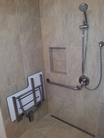 The remodeled bathroom, with tilt bench, long floor drain, and hand-held shower head. And a little cubby hole for shampoos, a nice touch added by the tilers.